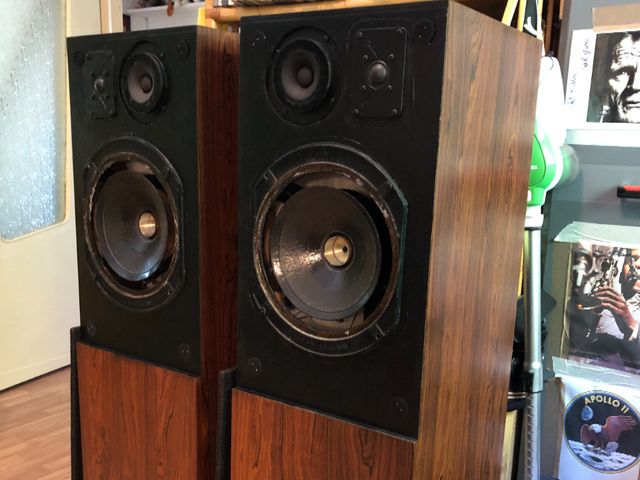 Dunque, parliamo un po’ di queste belle bellissime casse che avevano bisogno di me. Le AUDIONICS TL 90 sono dei diffusori nati nei primi anni settanta e avevano delle sorelle minori, le AUDIONICS TL 30 e TL 50. Quando vidi le per la prima volta una coppia di AUDIONICS erano i primi anni 80 e lavorando nel settore ero molto curioso di sentirne il suono per poterle confrontare con qualcosa di simile, le casse davanti a me erano le TL30 due monoliti alti e magri che allora erano “strani”ma sicuramente proiettati esteticamente già nel futuro. Queste casse montavano degli altoparlanti a dir poco ridicoli per quanto riguarda gli alti. Un woofer da 20 cm di origini Philips (sembrava)
con sospensione in gomma,e,per la parte riguardante le frequenze alte, due tweeterini Made in Giappone, a cono,molto ma molto semplici con sopra una scritta ben chiara, 5W !!!? arrivai alla prova di ascolto dubbioso e invece……mi si presentò un suono veramente affascinante , un basso pieno corposo più dinamico di un cono da 20 cm e con alti ariosi e dettagliati. Mi meravigliai del progetto costruttivo a linea di trasmissione e ne rimasi colpito. I difetti c’erano …. Il costo, la costruzione delle casse molto complessa e pesante,poca cosa per quello che riuscivano a restiturei  all’ascolto.
Oggi.Poco tempo fa mi capita di avere due diffusori AUDIONICS fra le mani ma …TL 90 , da “riattare”come mobile e altoparlanti. Entusiasticamente mi sono messo al lavoro giorno e notte fino alla conclusione del lavoro.
Prima di tutto i componenti, gli altoparlanti, tweetwr da sostituire..-fatto, due peerles simil cizek, M&C Ecc. I medi , molto robusti simil AR, ALLISON …molto “americani”,funzionanti, solo da pulire e provare. Due woofer da 25 cm  malconci da riconare ( in gomma) ripulire per bene e sostituire parapolvere, anzi proprio inserire perché a uno mancava.
Gli altoparlanti sono tutti marcati RADFORD, quel RADFORD degli amplificatori, peraltro molto ben suonanti. Stranamente Inglesi?
Ma insomma casse americane, molto americane ma con componenti inglesi, compreso il crossover non me lo sono ancora spiegato, forse una collaborazione o acquisizione!!?
Comunque il restauro va avanti. Pulizia interna ed esterna con rincollaggio impiallacciatura un po’ dappertutto e sistemazione portafusibili esterni, pulizia crossover e rimontaggio altoparlanti previo controllo materiale assorbente, che non mancava.
Passato un giorno dal rifacimento totale, altoparlanti mobile ecc.
Si può passare all’ascolto con calma, molta calma.
Pezzi di classica, jazz, moderna insomma di tutto un po’. E indovinate cosa ho sentito…. Una coppia di casse con un suono inimmaginabile se non le si conosce,altoparlanti molto buoni per la loro età .  Non riesco a spiegare le sensazioni acustiche, medi e alti precisi ma i bassi, i bassi sono indescrivibili. Bisogna solo sentire.
Non è possibile assolutamente rimandare al lettore le sensazioni e la varietà  del dettaglio musicale che si percepisce.Filosoficamente parlando ci si rimanda all’acustica inreale del suono riprodotto in casa,ma semplicemente perfetto, pieno di frequenze alte ,basse,medie sgranate in ambiente delicatamente. Non so se mi spiego? Credo proprio di NO. QUESTO È TUTTO PERÒ.